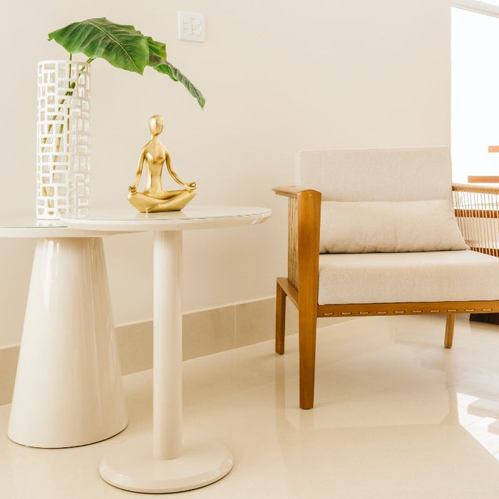 plant and chair and golden statue in lotus position