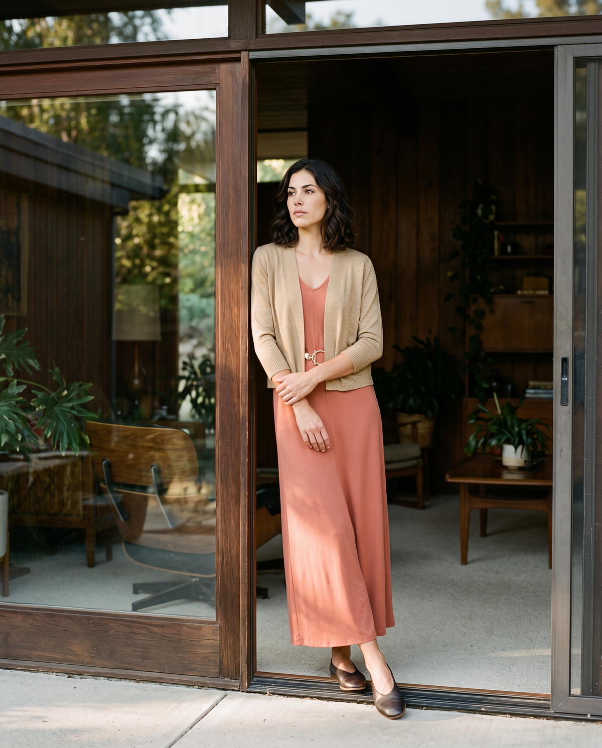 Woman in a black bamboo yoga wrap leaning on a porch rail above a green valley